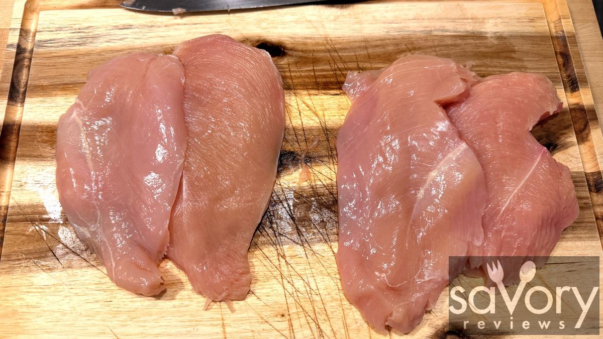 Raw chicken breasts sliced in half into cutlets