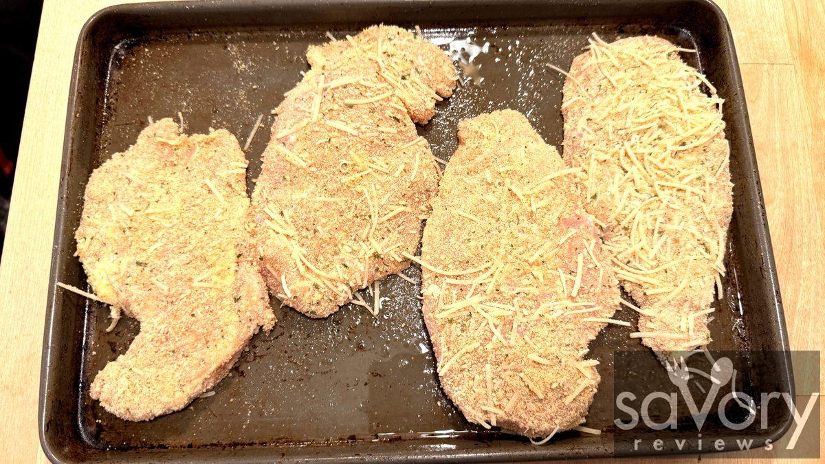 Chicken cutlets dredged in breadcrumb mixture on the pan