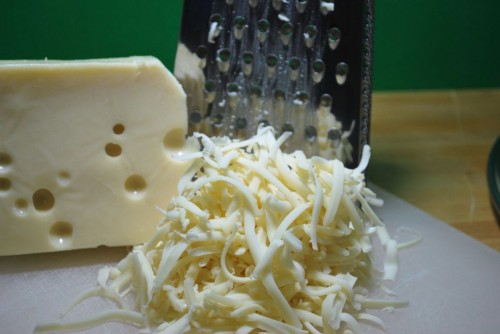 Shredding the cheese your self will give you a cheaper way to top pizza.