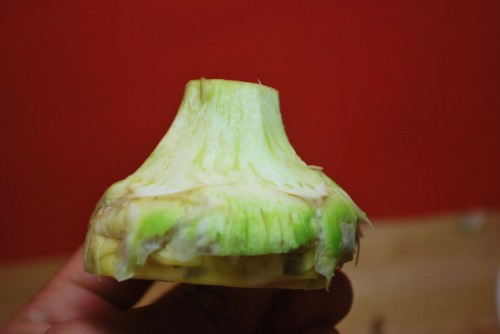 Peel the harder outer layers off of the artichoke.