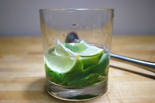 Muddle the limes, mint and rum