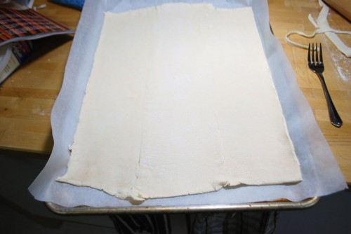 Roll it out to the size of your cookie sheet, do the best you can, puff pastry does not always cooperate.