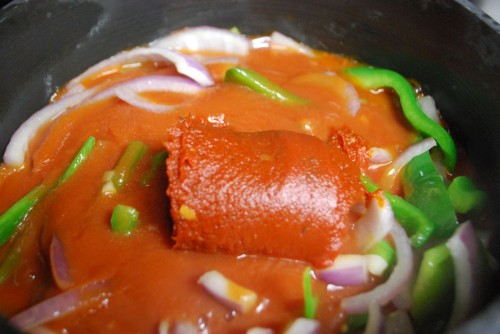 Add the sauce and tomato paste, opening both ends of the tomato paste can will allow you to push out all of the paste.