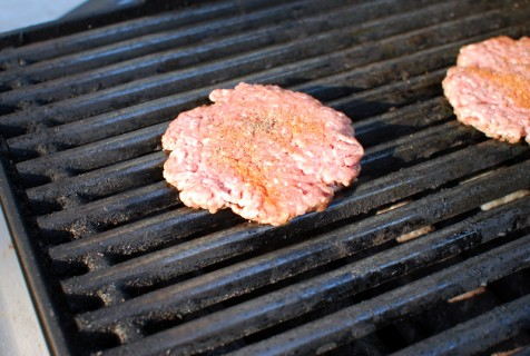 Place the burger directly over the heat and season lightly with seasoning salt